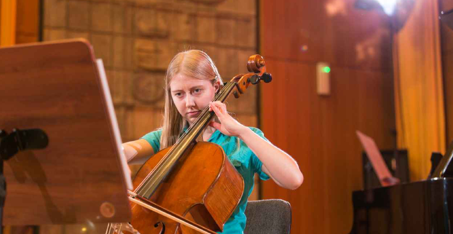 A Young Girl Practicing musical notes with her cello.