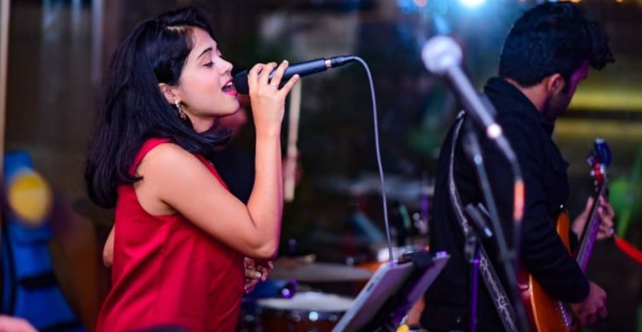 Female Lead Vocalist Singling in Studio with Musical Instruments.