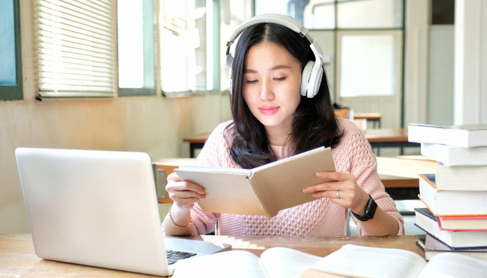 Calm and Young Beautiful Girl Listening Music While Studying.