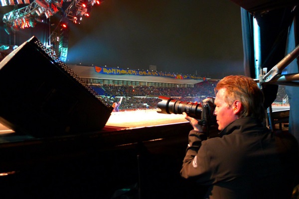 Image Featuring A Professional Event Photographer Taking Photos Of A Musical Concert.