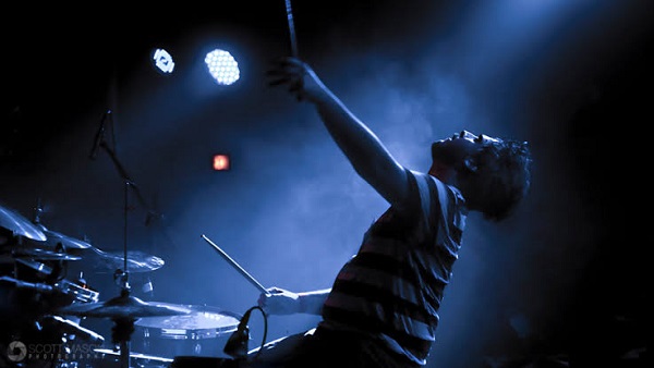 An Image Of Male Lead Drummer Enjoying His Performance On The Stage.